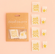 Load image into Gallery viewer, Woven center fold labels by Sarah Hearts white with gold Made with Joy and small stars and a separate small gold star label on white for stockings holiday Christmas sewing projects quilts reusable gift bags tree skirt