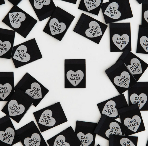 Woven label by Sarah Hearts black background with silver white heart and Dad Made It in type inside the heart for clothing garments bags costumes totes 