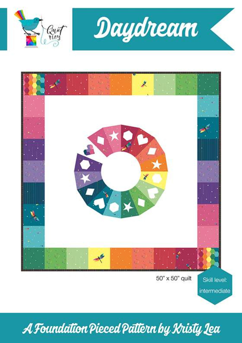 Daydream quilt pattern by Kristy Lea aka Quiet Play Foundation Paper Pieced color wheel center in rainbow fabrics with stars hearts diamonds hexie geometric shapes and rainbow checkerboard pattern Riley Blake Designs skill level intermediate
