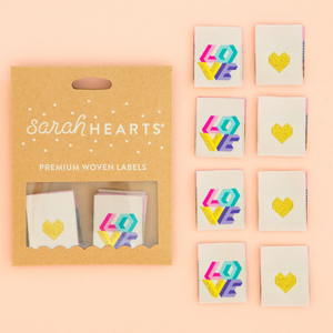 Sarah Heart double fold premium labels for quilts garments clothing bags sewing projects Tied with a Ribbon Love in rainbow colors on cream background and gold heart
